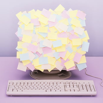 Computer monitor covered in multicolored sticky notes